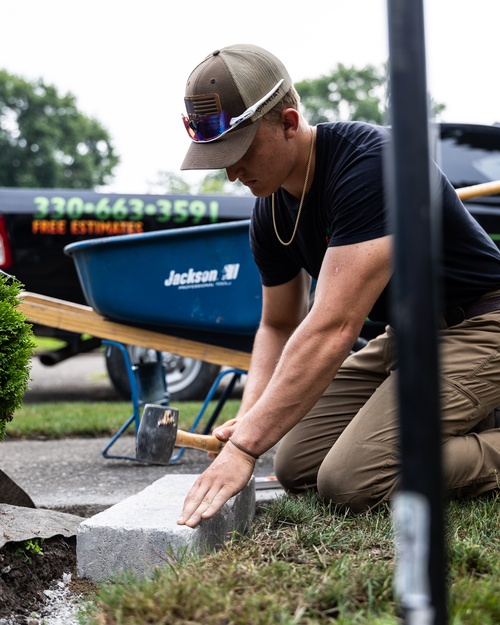 Crew member setting the base course of a retaining wall