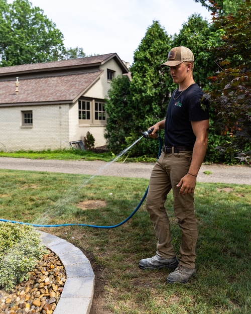 Ace Lawn & Landscape crew member treating a landscape bed edge