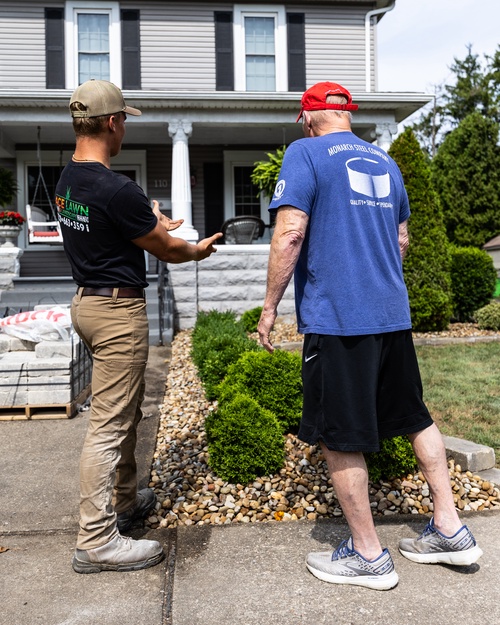 Ace Lawn & Landscape crew member talking with a customer at their home