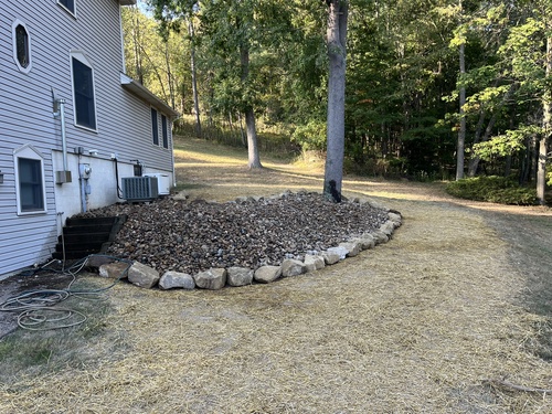 Decorative rock bed installed with a stone border in the off season